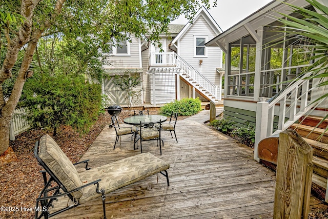 659 Wash Woods Way, Bald Head Island, NC 28461 - wooden deck with stairway, outdoor dining area, and a sunroom