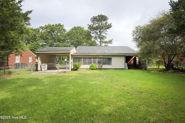 rear view of property with a gate, a sunroom, and an attached carport