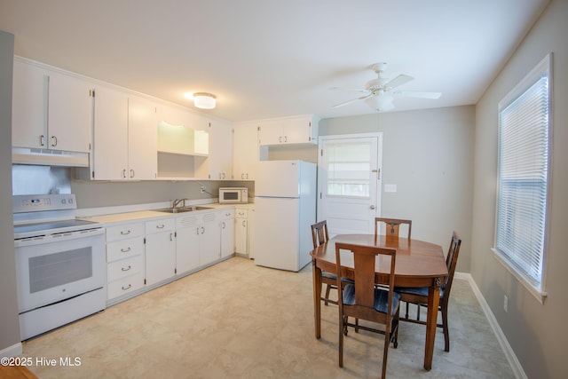 kitchen featuring white appliances, under cabinet range hood, a sink, ceiling fan, and white cabinetry