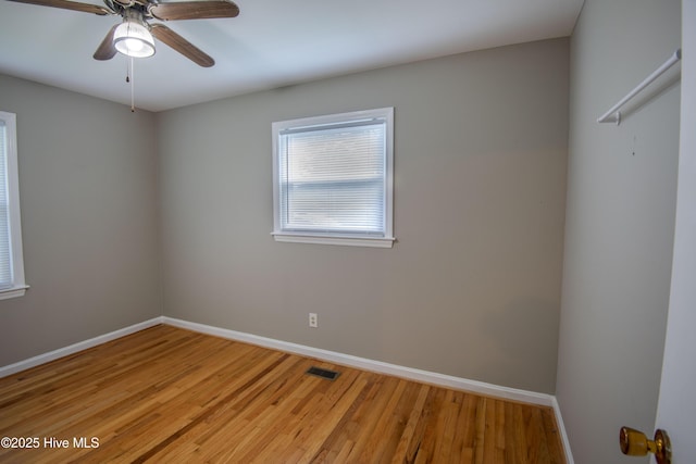 spare room with baseboards, light wood-style floors, and ceiling fan