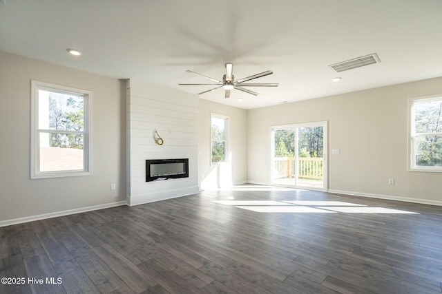 unfurnished living room with a ceiling fan, dark wood-type flooring, a large fireplace, baseboards, and recessed lighting