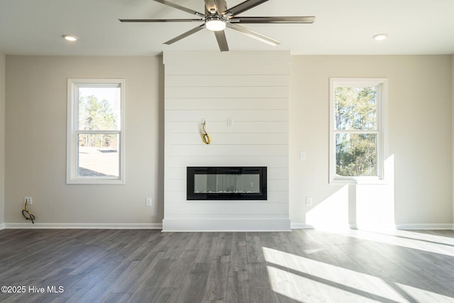unfurnished living room with wood finished floors, a fireplace, ceiling fan, baseboards, and recessed lighting