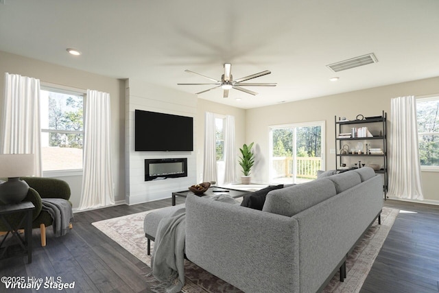 living area featuring a ceiling fan, dark wood-type flooring, a fireplace, baseboards, and recessed lighting