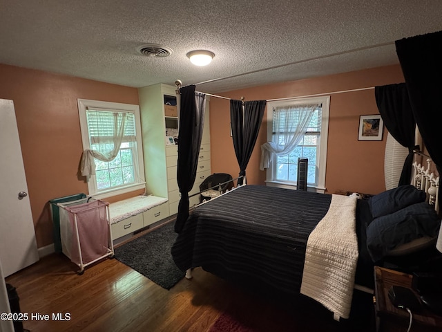 bedroom with wood finished floors and a textured ceiling