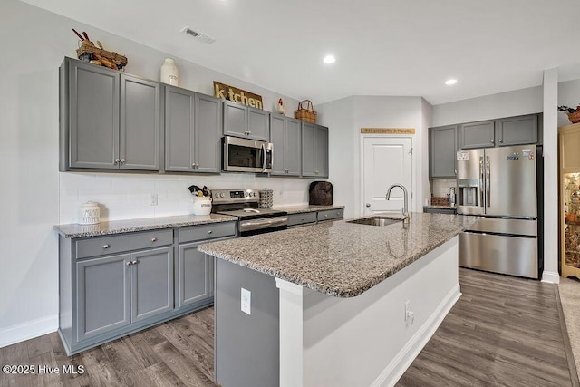 1592 E New Carraway Pl SE, Bolivia, NC 28422 - kitchen featuring stainless steel appliances, a sink, gray cabinets, light stone countertops, and dark wood-style flooring