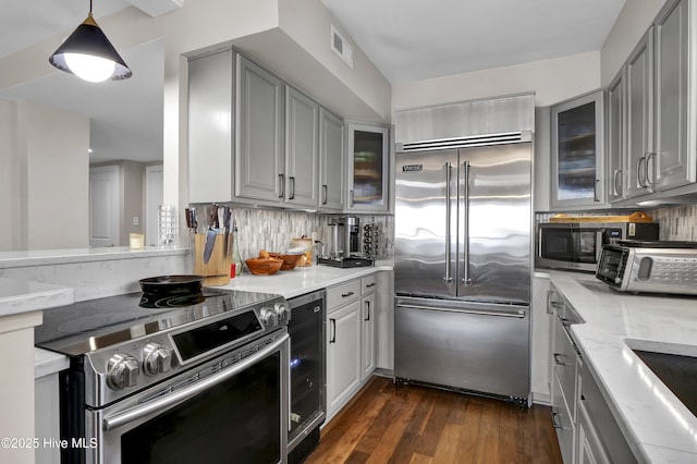 kitchen featuring appliances with stainless steel finishes, gray cabinets, and tasteful backsplash