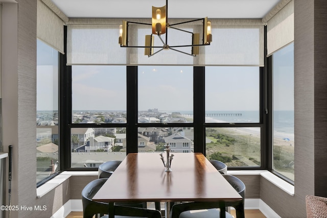 dining space with a chandelier, plenty of natural light, baseboards, and wood finished floors