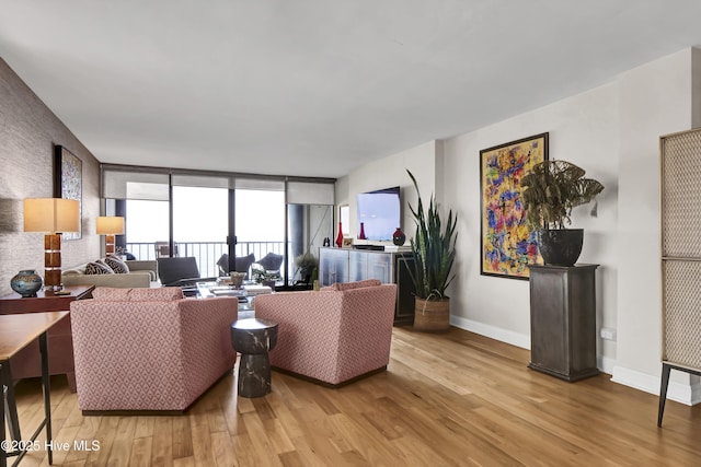 living room featuring wood finished floors, baseboards, and expansive windows