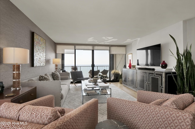living room with expansive windows and light wood finished floors