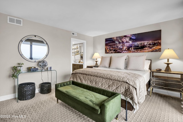 carpeted bedroom featuring ensuite bathroom and baseboards