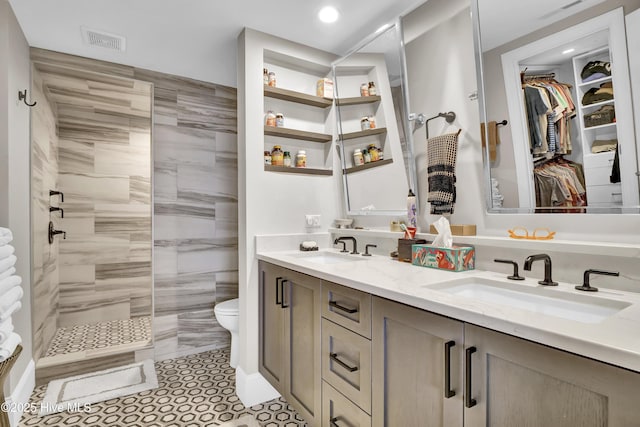 bathroom featuring a walk in shower, toilet, double vanity, recessed lighting, and a spacious closet