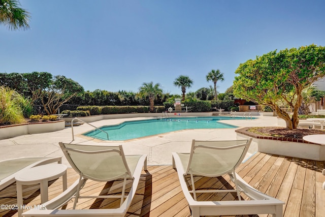 community pool with a patio and fence
