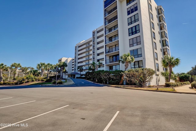 view of apartment building / complex with uncovered parking