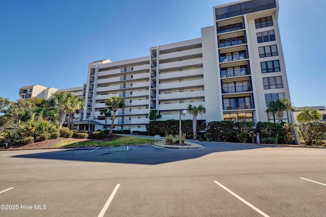 view of apartment building / complex featuring uncovered parking