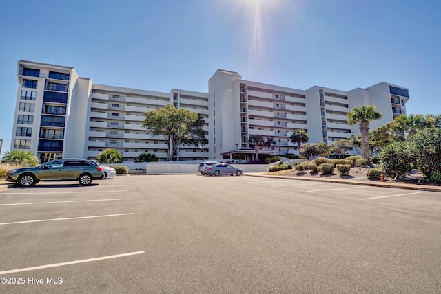view of apartment building / complex with uncovered parking