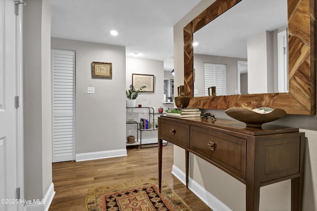 hall with baseboards, light wood-style flooring, and recessed lighting
