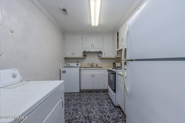 4512 Rivershore Dr, New Bern, NC 28560 - laundry area featuring a textured ceiling, dark flooring, ornamental molding, and washer and dryer
