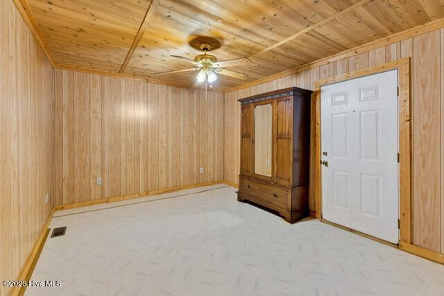 660 Beachview Dr SE, Bolivia, NC 28422 - unfurnished room featuring ceiling fan, wooden ceiling, wood walls, and baseboards