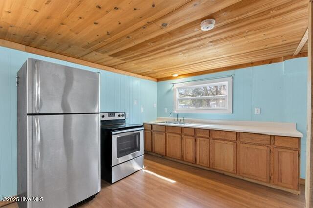 660 Beachview Dr SE, Bolivia, NC 28422 - kitchen featuring stainless steel appliances, wood ceiling, light wood finished floors, brown cabinets, and light countertops