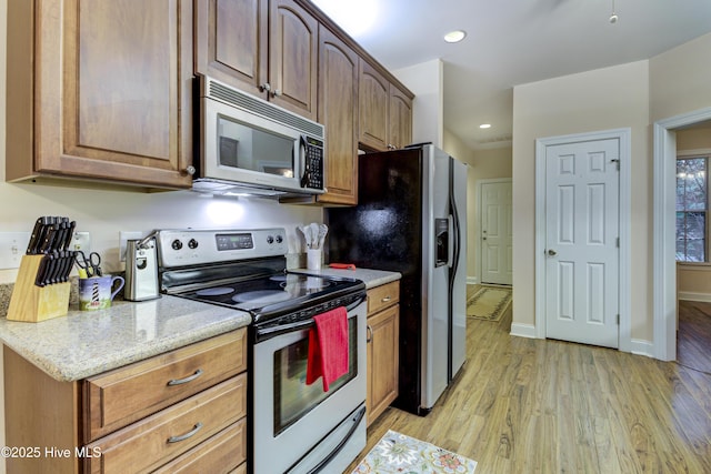 203 Abbey Ln, Wilmington, NC 28411 - kitchen with stainless steel appliances, light wood finished floors, light stone counters, recessed lighting, and baseboards
