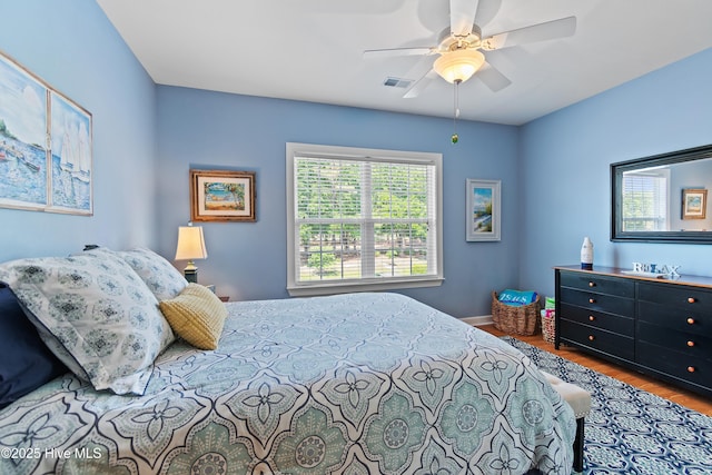 bedroom with wood finished floors, baseboards, and a ceiling fan