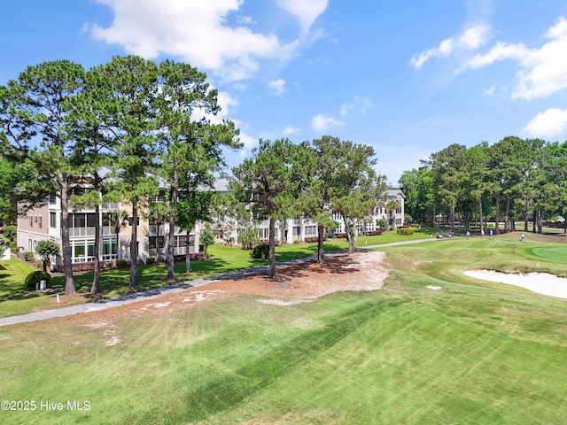 view of home's community featuring golf course view and a lawn