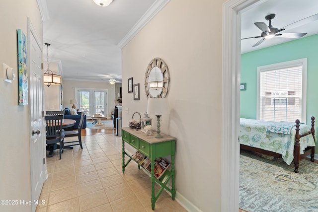 hallway featuring crown molding, baseboards, and light tile patterned floors