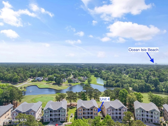 drone / aerial view of a nearby body of water, a golf club, and a heavily wooded area