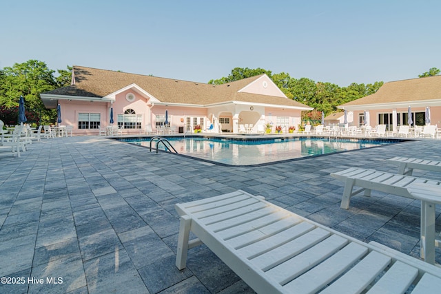 community pool featuring a patio and fence