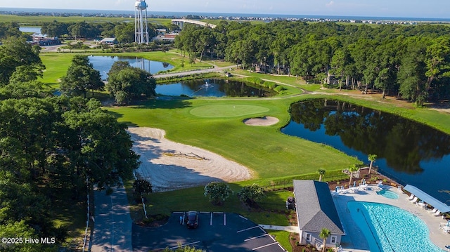 drone / aerial view of a nearby body of water and a pool area