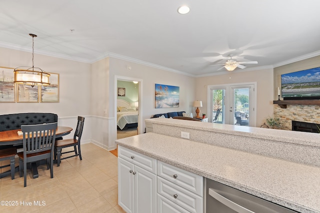 kitchen with crown molding, a ceiling fan, white cabinetry, stainless steel dishwasher, and decorative light fixtures