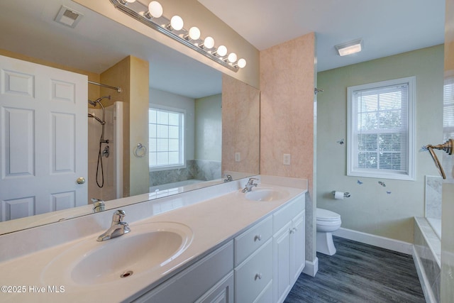 176 Lewis Rd, Hampstead, NC 28443 - bathroom with toilet, a garden tub, double vanity, wood finished floors, and baseboards