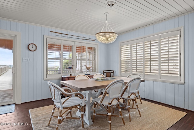 5709 Ocean Dr, Emerald Isle, NC 28594 - dining space with dark wood-style floors, a chandelier, and wooden walls