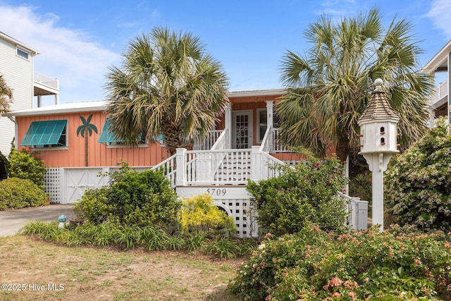 5709 Ocean Dr, Emerald Isle, NC 28594 - view of front of home with an attached garage, driveway, board and batten siding, and stairway