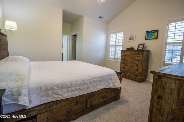 bedroom featuring light carpet, multiple windows, baseboards, and high vaulted ceiling