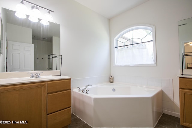bathroom featuring vanity, tile patterned floors, a garden tub, and vaulted ceiling