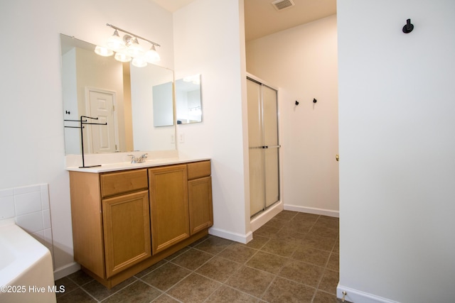 bathroom with a shower stall, vanity, a garden tub, baseboards, and tile patterned floors