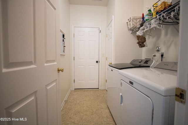 clothes washing area with washing machine and dryer and baseboards