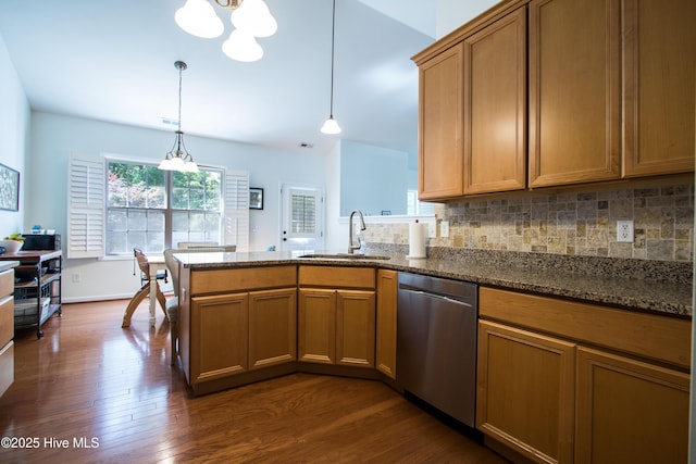 kitchen featuring a sink, stainless steel dishwasher, a chandelier, a peninsula, and dark wood-style floors