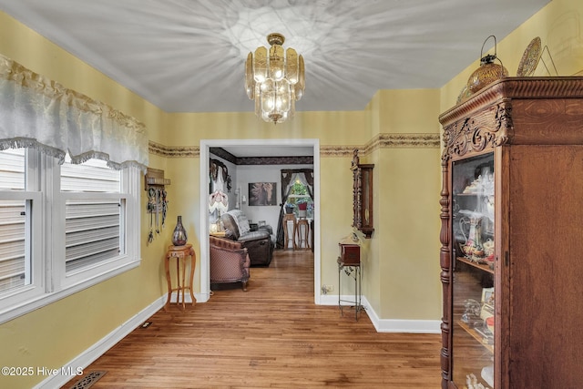 2601 Mayberry Loop Rd, Morehead City, NC 28557 - hall featuring a chandelier, wood finished floors, healthy amount of natural light, and baseboards