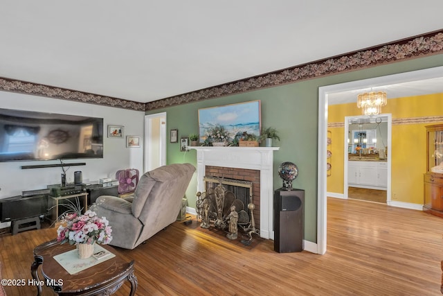 2601 Mayberry Loop Rd, Morehead City, NC 28557 - living area with wood finished floors, a chandelier, a fireplace, and baseboards