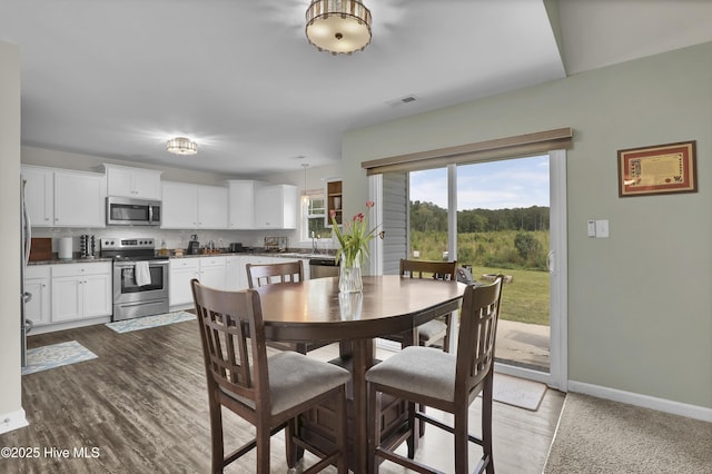 dining space featuring wood finished floors and baseboards