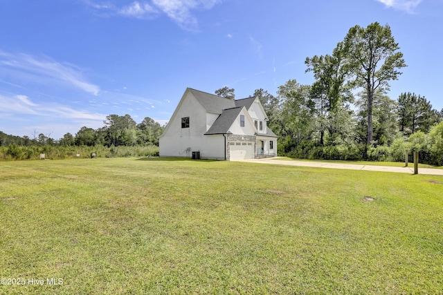 view of property exterior with an attached garage, driveway, a yard, and view of scattered trees