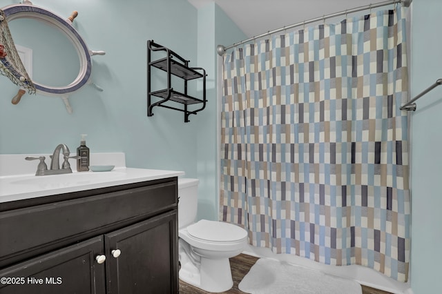 bathroom with toilet, vanity, and a shower with curtain