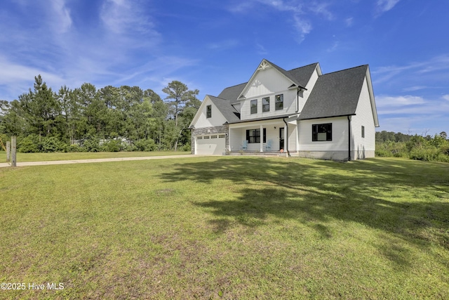view of front of home with a porch, a garage, and a front lawn