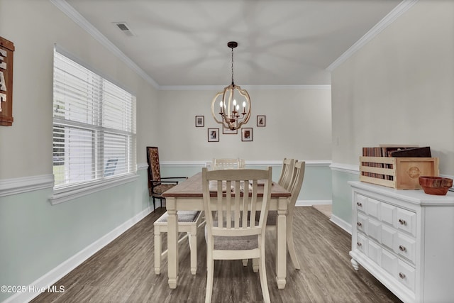 dining area featuring a chandelier, dark wood finished floors, crown molding, and baseboards