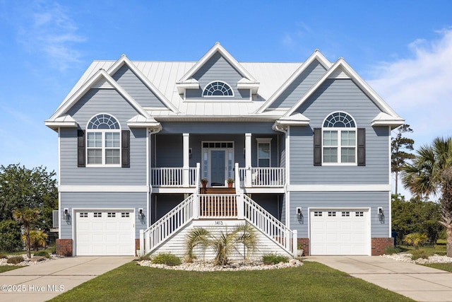 beach home featuring an attached garage, driveway, a porch, and stairs