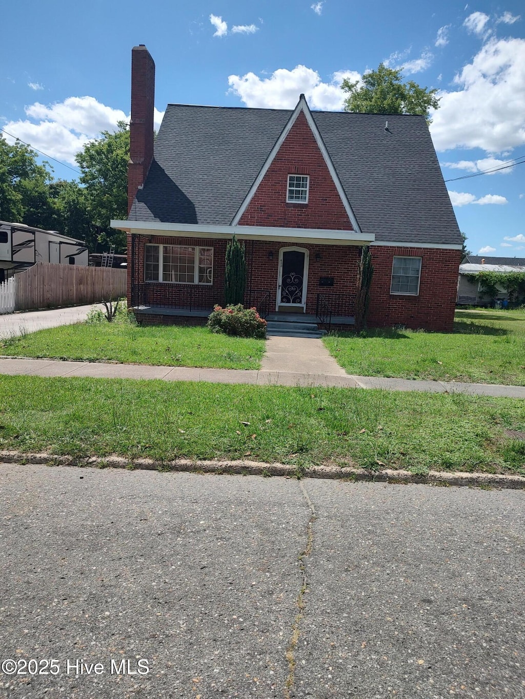403 S William St, Goldsboro, NC 27530 - tudor home featuring brick siding, a chimney, and a shingled roof
