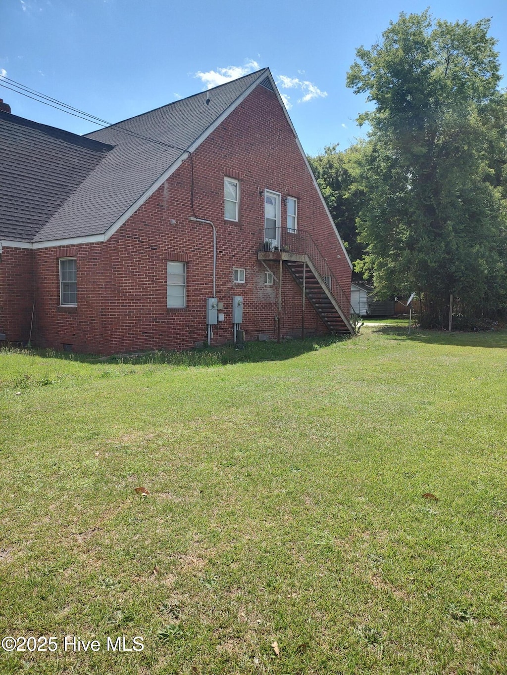 403 S William St, Goldsboro, NC 27530 - view of property exterior featuring brick siding, a yard, and stairs