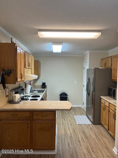 115 Oak Hills Dr, Rocky Point, NC 28457 - kitchen with ornamental molding, light countertops, brown cabinets, a textured ceiling, and light wood-type flooring